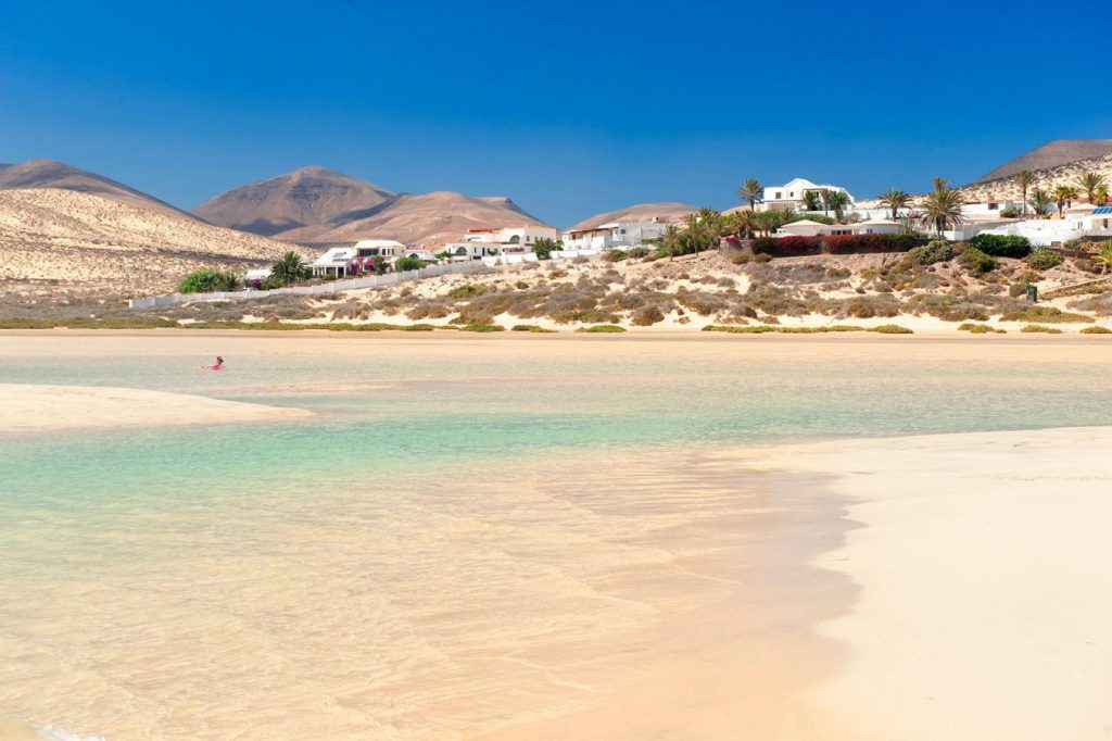 White-sand beach in Fuerteventura with turquoise water, soft dunes, and clear Atlantic skies