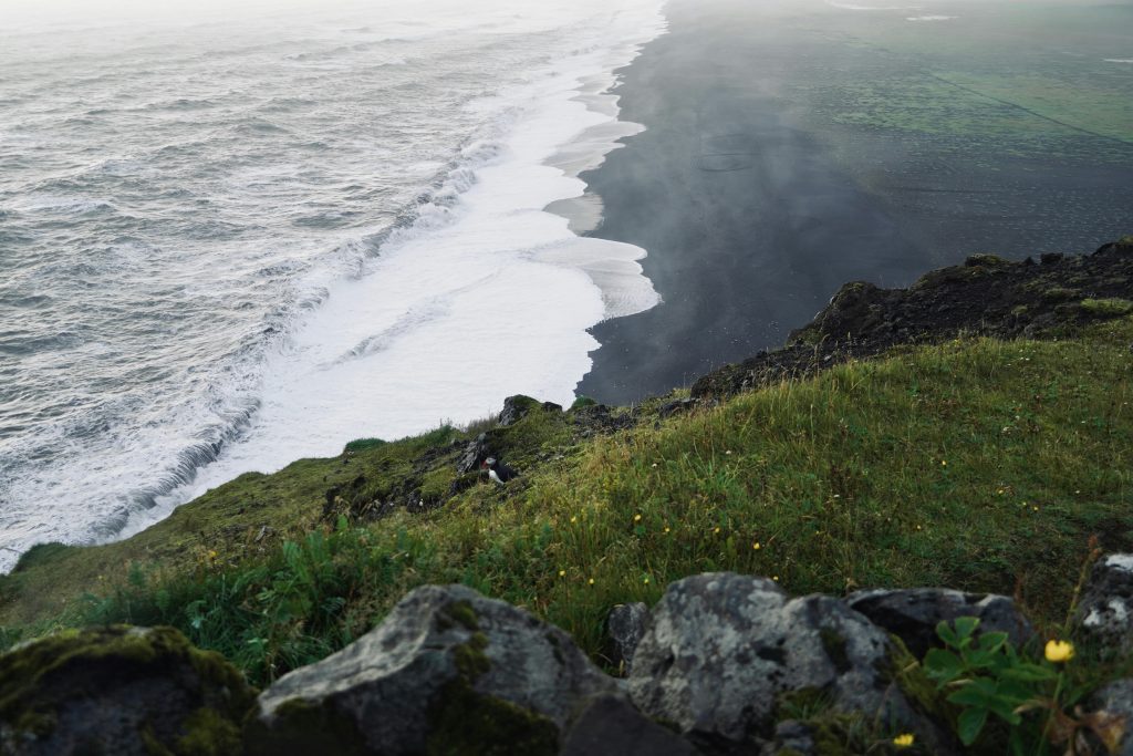 Canary Islands coastline showing calm resort beach on one side and wild Atlantic waves on the other