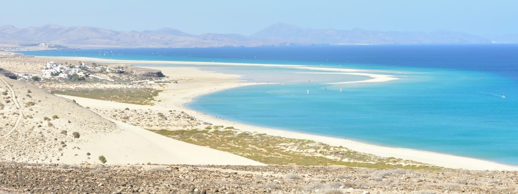 Cofete Beach in Fuerteventura with wild Atlantic waves, remote coastline, and mountains in the background