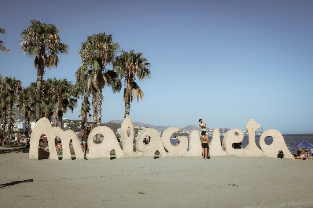 La Malagueta Beach in Málaga with sandy shore, palm trees, and Mediterranean Sea