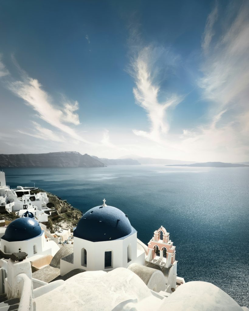 Santorini island in Greece with white houses and blue domes overlooking the Aegean Sea