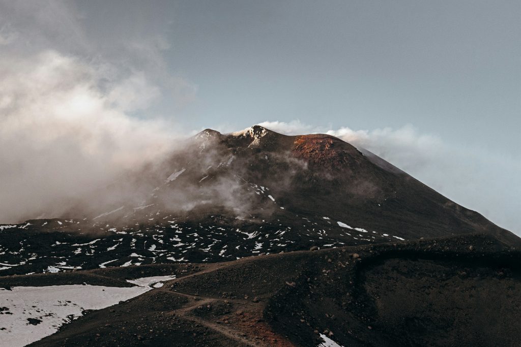 Mount Etna volcano in Sicily with lava fields and sea view