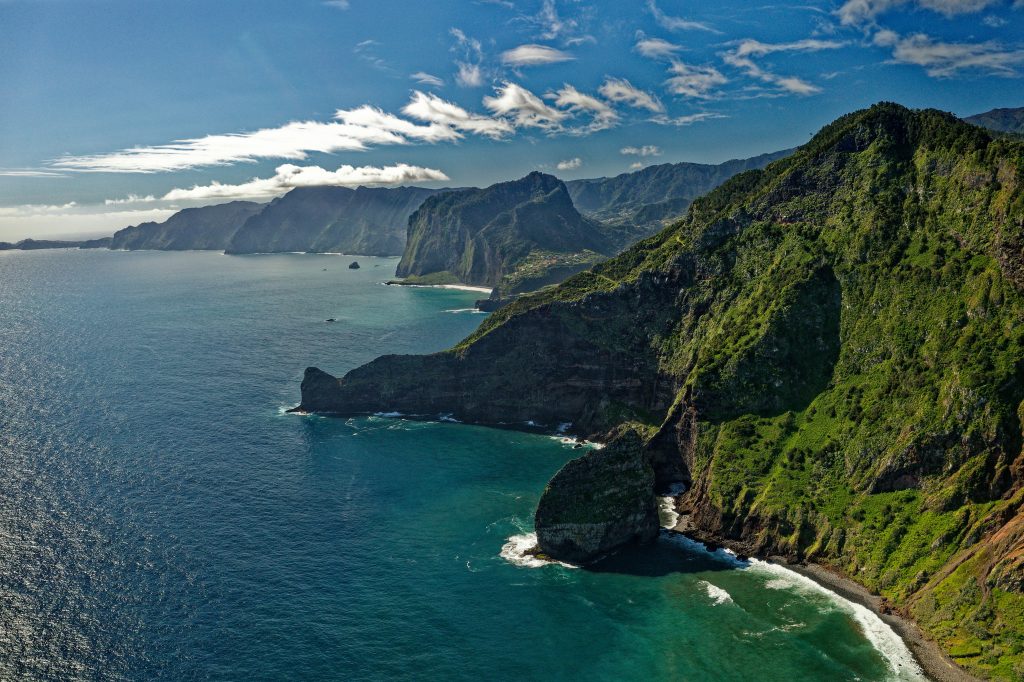 Madeira island coastline with steep cliffs, ocean views, and lush subtropical landscapes