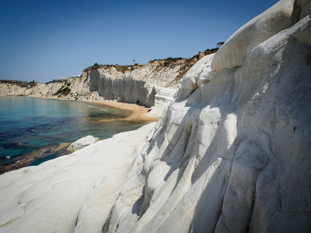 Scala dei Turchi in Sicily featuring dramatic white limestone cliffs shaped like steps descending into turquoise Mediterranean sea