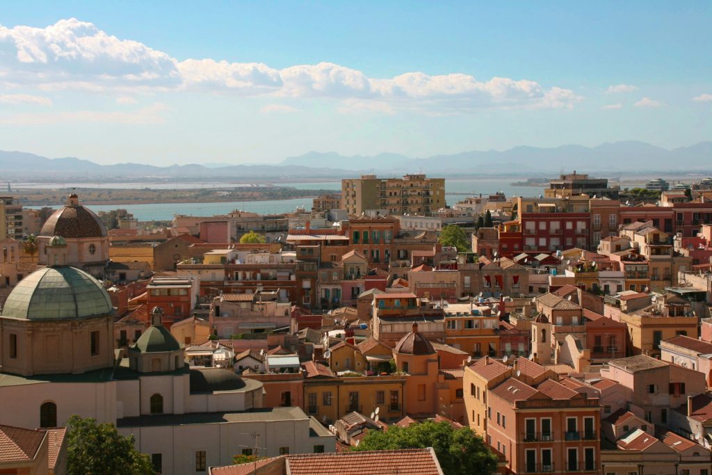 The colorful capital city of Cagliari in South Sardinia, Italy, showing its mix of Roman history, medieval architecture, and coastal charm.