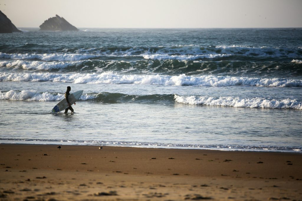 Peniche surf beach with long sandy shoreline, Atlantic swells, and surfers preparing for competitions