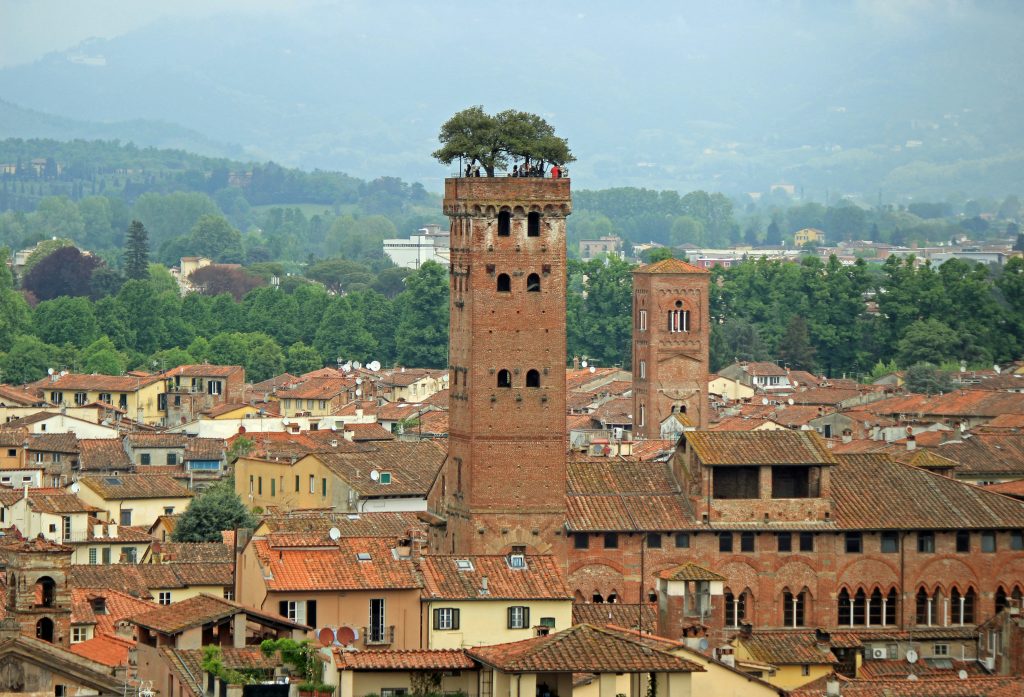 Lucca historic city walls turned into a tree-lined cycling path, with people riding bicycles around the old town under Renaissance fortifications in Tuscany