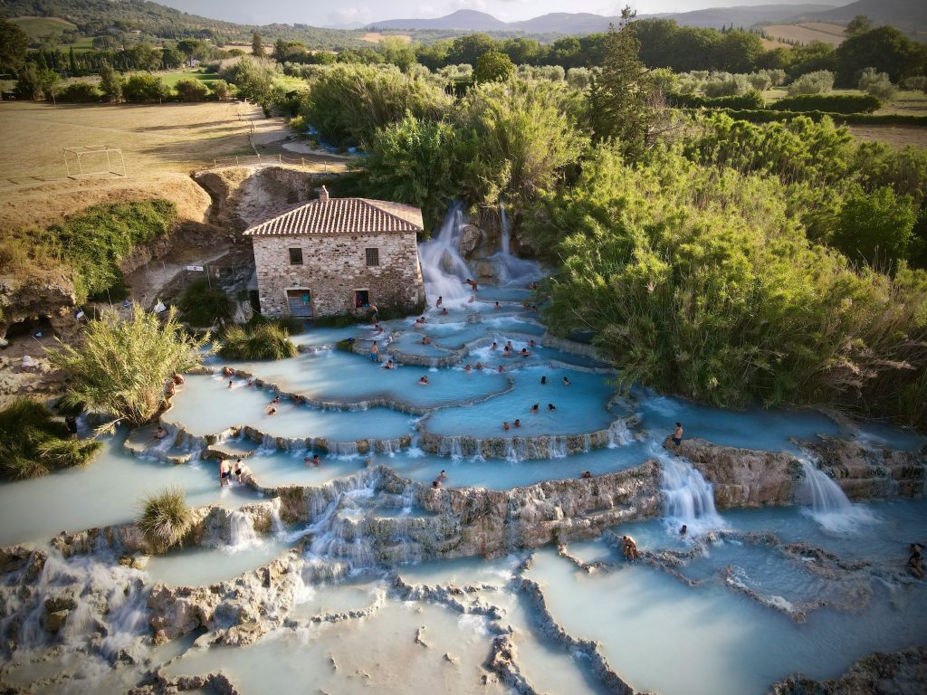 Saturnia Cascate del Mulino natural hot springs with turquoise limestone pools, steaming thermal water at 37°C, and open countryside surroundings, offering a free open-air wellness experience in Tuscany.