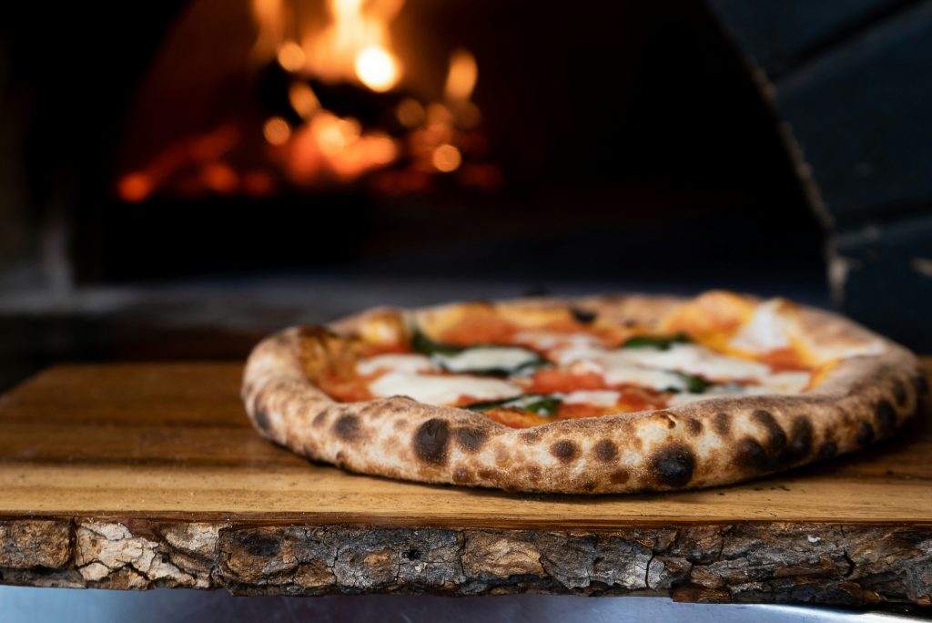 Authentic Neapolitan pizza with tomato sauce, mozzarella, and basil baked in a wood-fired oven