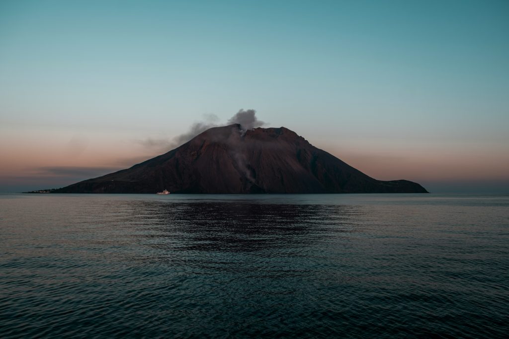 Stromboli active volcano in Sicily erupting at night with glowing lava and dramatic volcanic coastline in the Aeolian Islands