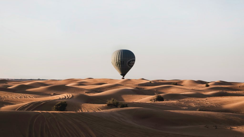 Hot air balloon ride over Dubai desert at sunrise with wide desert landscape