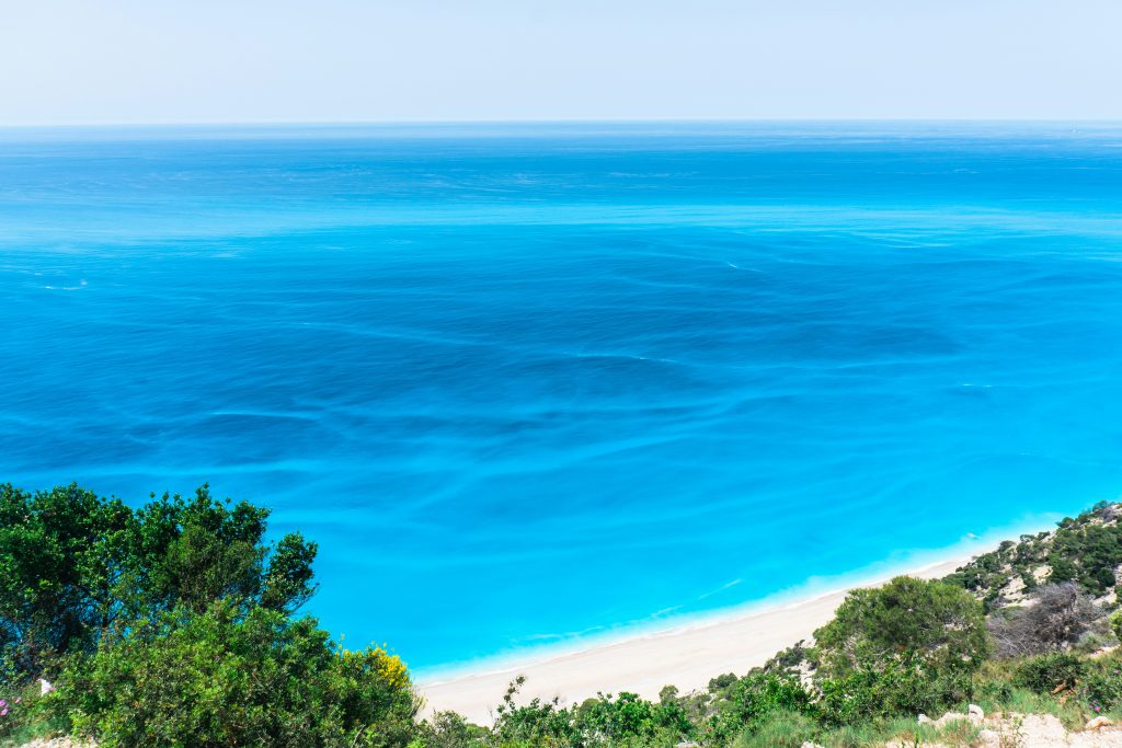 Egremni Beach in Lefkada featuring long wild coastline, vertical limestone cliffs and clear blue Ionian water.