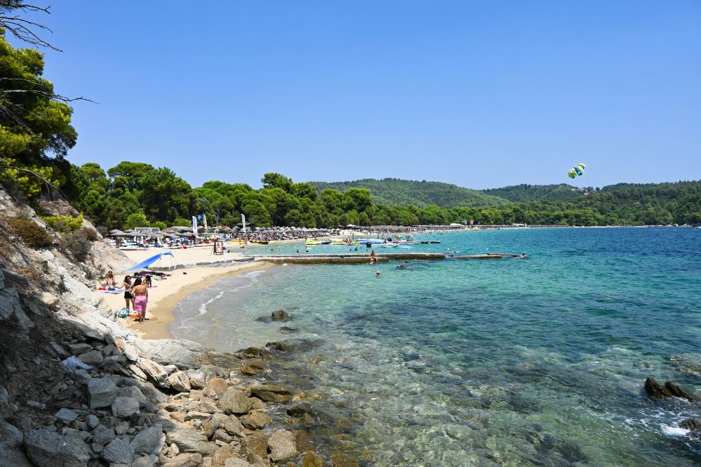 Golden sandy Koukounaries Beach in Skiathos with shallow turquoise water and pine forest backdrop
