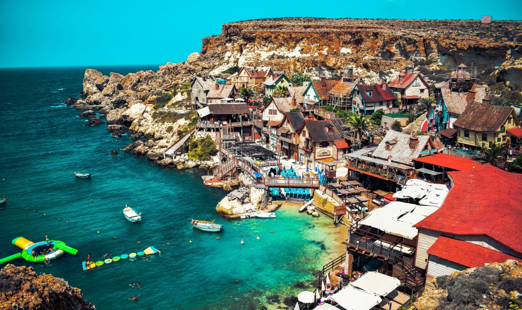 Malta travel guide Popeye Village colorful houses Anchor Bay coastal view Mediterranean island