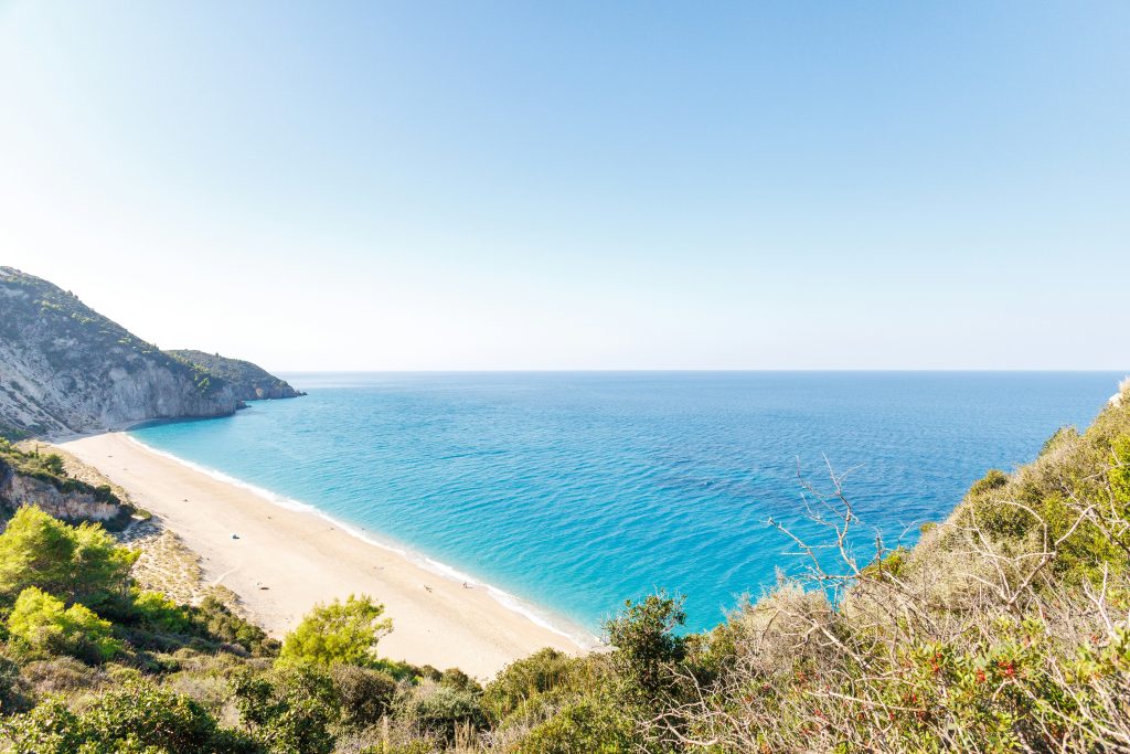 Milos Beach Lefkada near Agios Nikitas with crystal-clear turquoise water, white cliffs and natural unorganized shoreline.