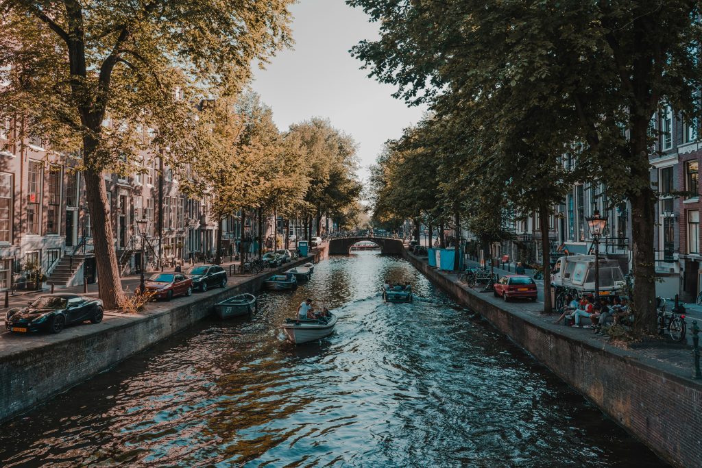 Amsterdam canals with boats and traditional houses – what to know before visiting Amsterdam