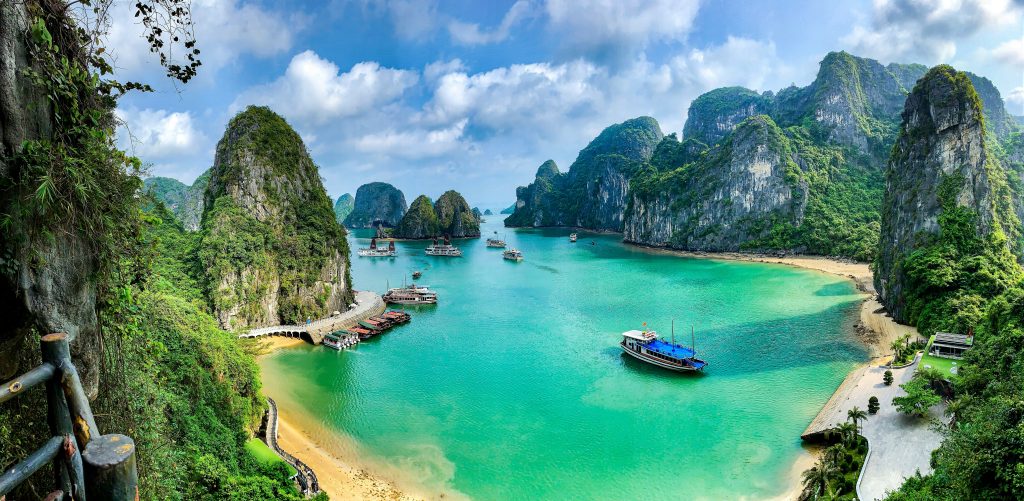 Ha Long Bay limestone cliffs and cruise boats on the water – Vietnam travel guide