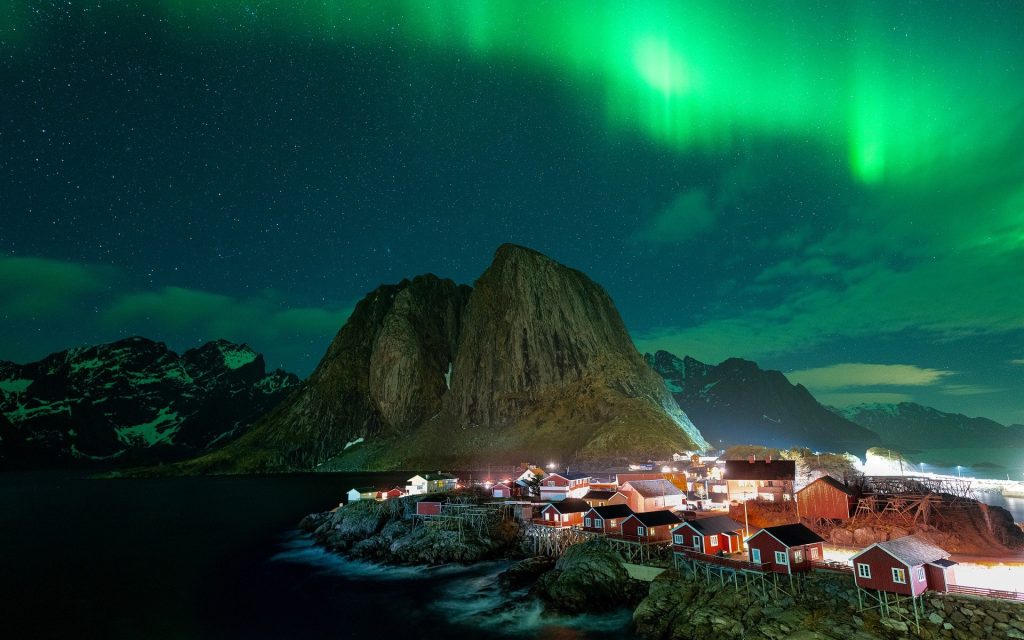Norway fjords northern lights over coastal village with mountains and ocean landscape in Norway