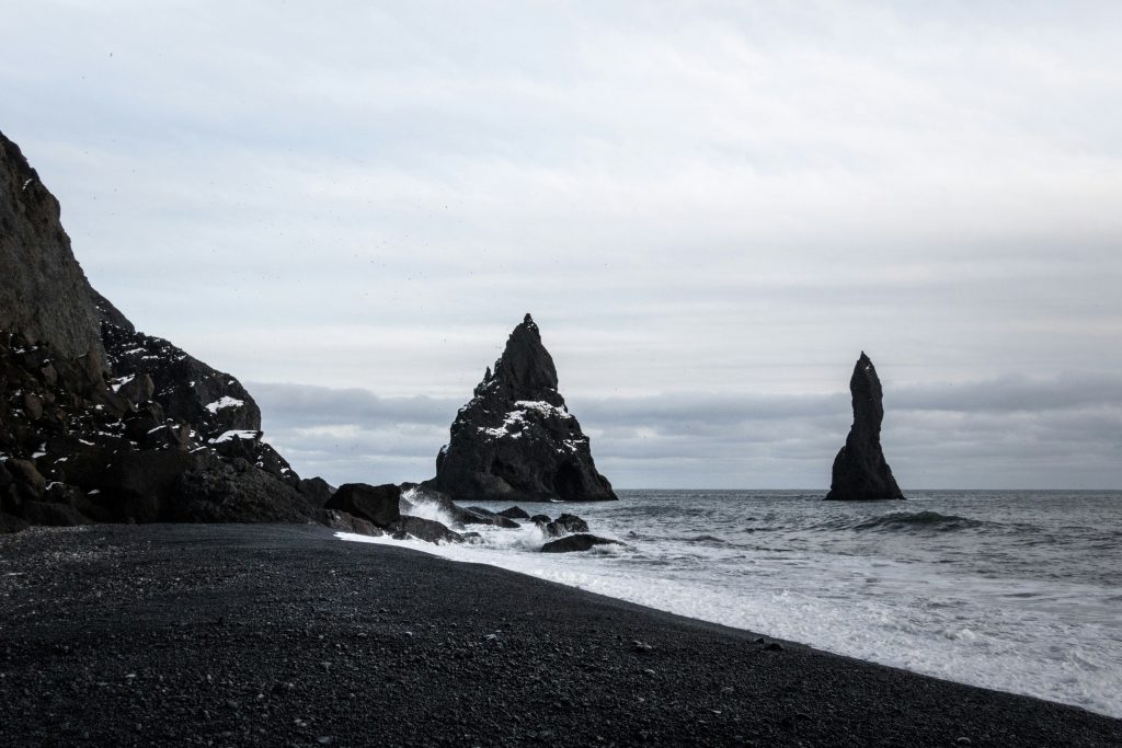Reynisfjara black sand beach in Iceland with waves and dramatic coastline