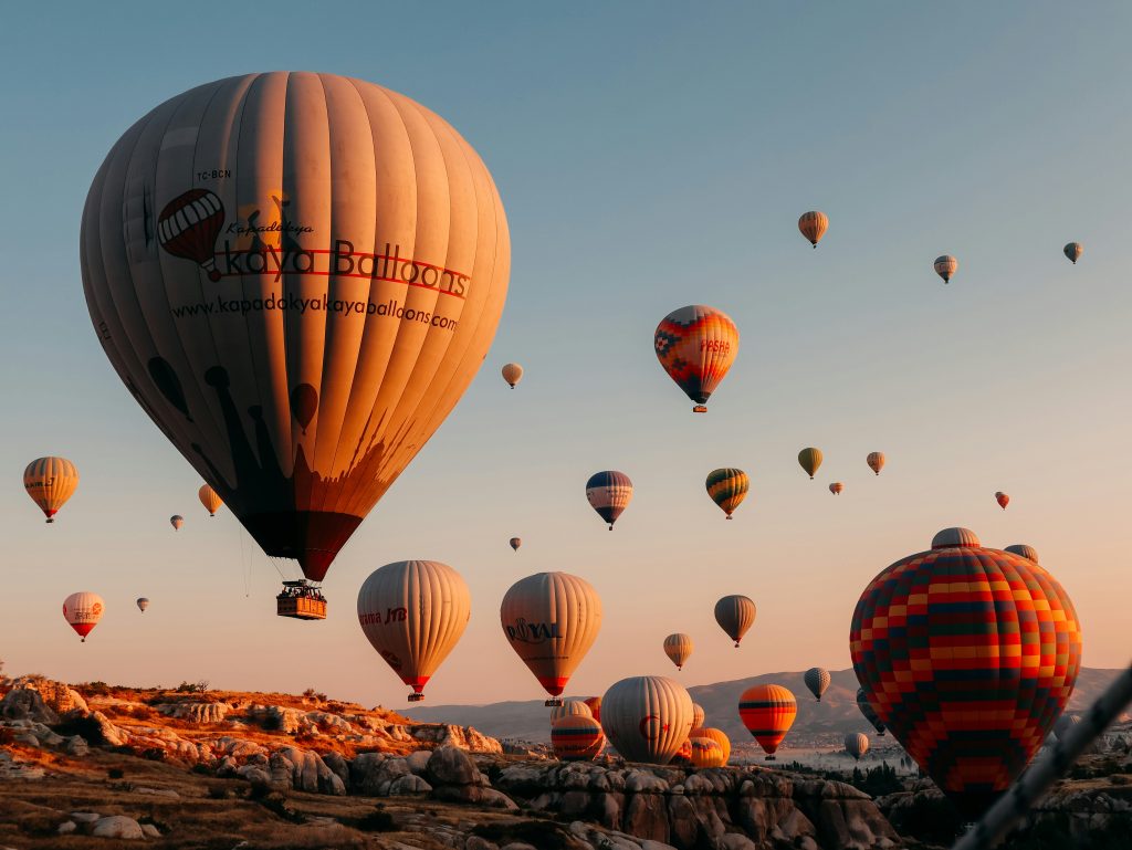Colorful hot air balloons above Cappadocia rock formations and valleys