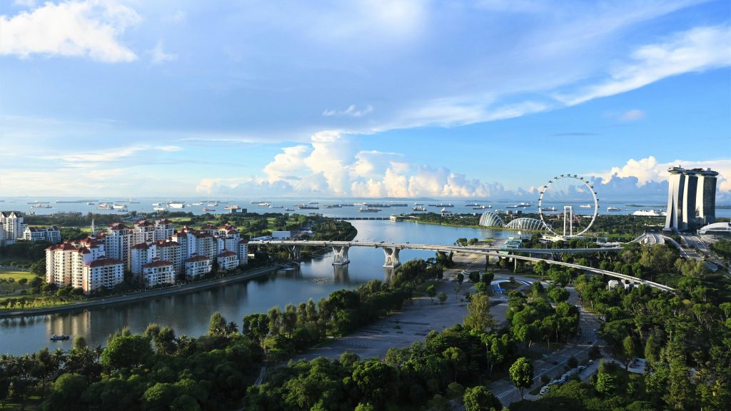 Aerial view of Sentosa Island, waterfront skyline, Marina Bay Sands, and coastal attractions in Singapore