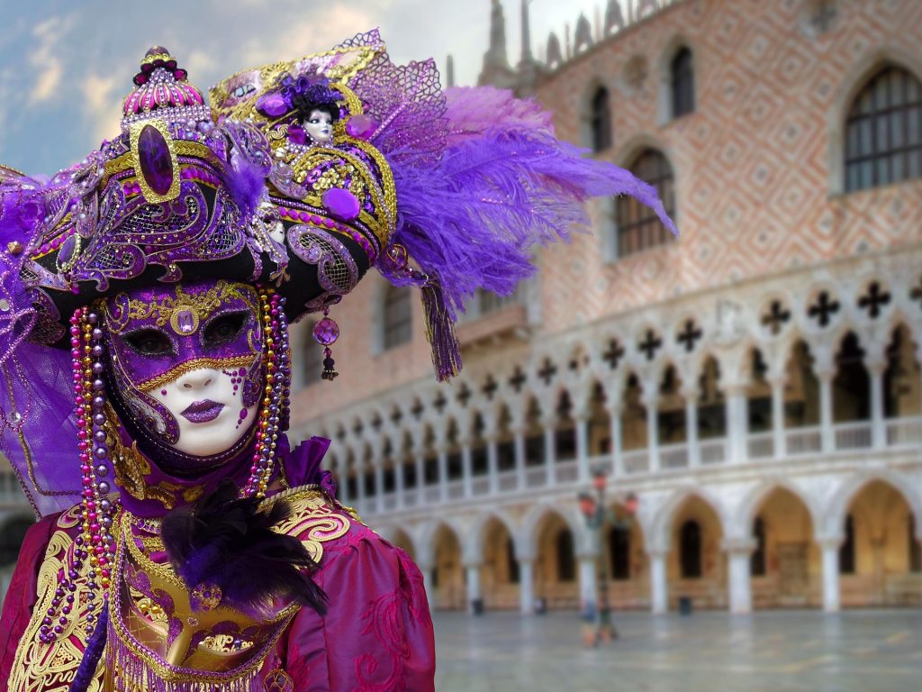 Person in an elaborate Venetian Carnival mask and costume in Venice