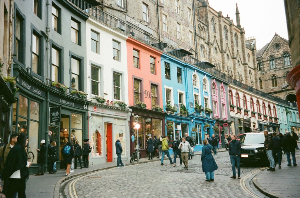 Colorful curved street filled with independent shops and historic buildings