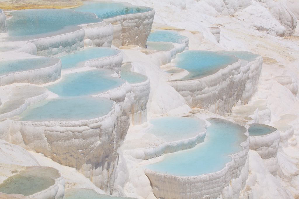 Iconic travertine pools in Pamukkale showcasing white mineral formations and turquoise thermal waters