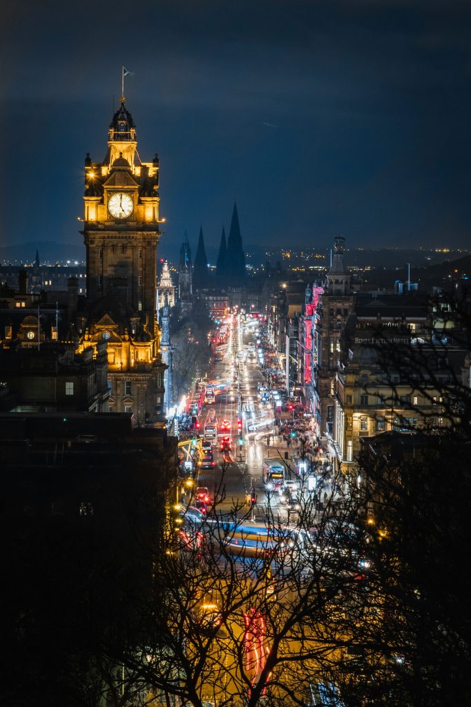 Nighttime city skyline with illuminated landmarks and busy streets
