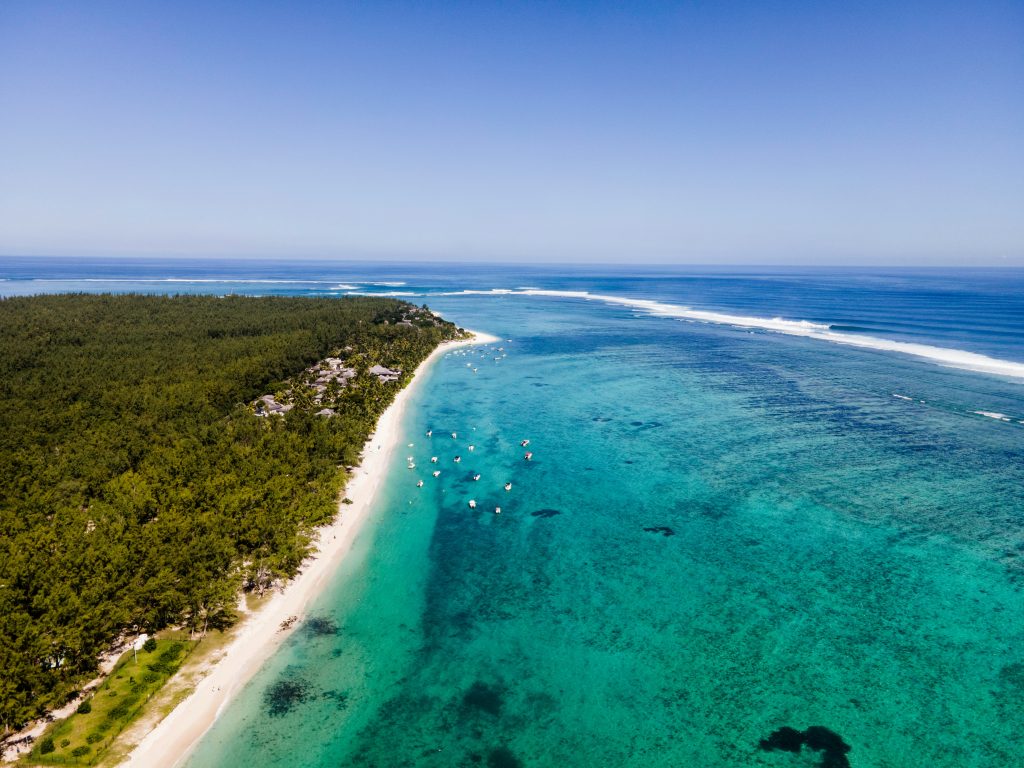 Trou aux Biches beach viewed from above with crystal-clear water and tropical coastline